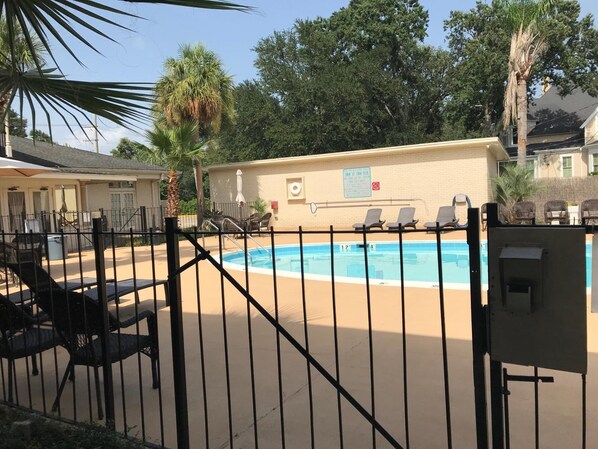 Una piscina al aire libre, sombrillas, sillones reclinables de piscina