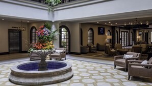 Eine Lobby mit Springbrunnen, Sitzgelegenheiten und einer Rezeption.