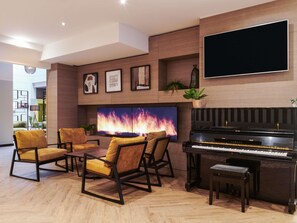 A modern living room with a piano, comfortable seating, a large TV, and decorative wall art. - Mercure Nantes Centre Grand Hotel (Nantes)