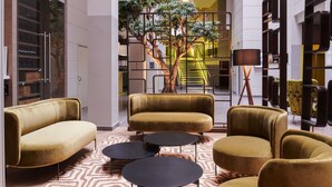 Een modern interieur met banken, een kamerbreed tapijt en een trap op de achtergrond.