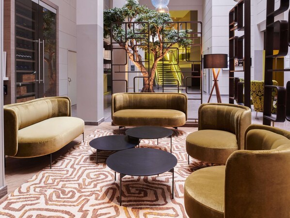 Een modern interieur met banken, een kamerbreed tapijt en een trap op de achtergrond.