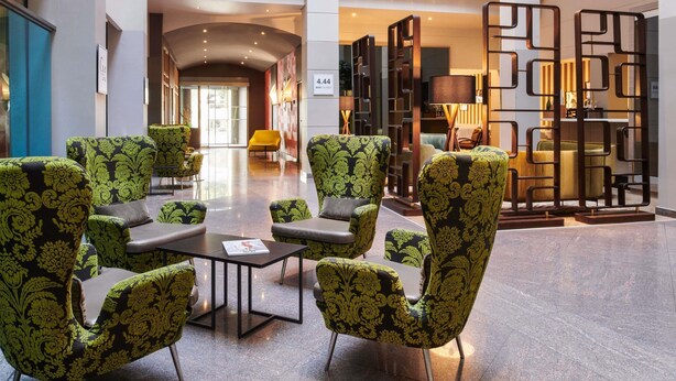 Een hal met moderne meubels, een bar/loungehoek en uitzicht op het interieur.