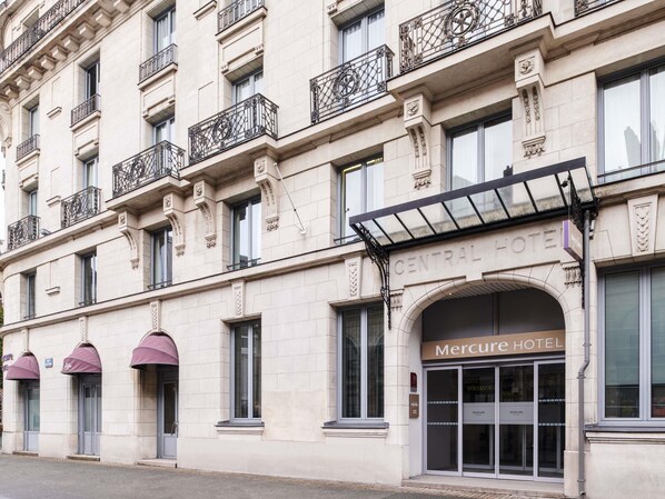 Een gebouw met een bord waarop 'Central Hotel' en 'Mercure Hotel' staat, wat een hotel aangeeft.
