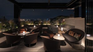 A rooftop lounge with modern seating, ambient lighting, and a city view. - InterContinental Rome Ambasciatori Palace by IHG (Rome)