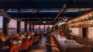 A rooftop bar with a glass ceiling, seating, and a bar stocked with bottles. - InterContinental Rome Ambasciatori Palace by IHG (Rome)