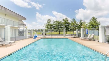 Una piscina al aire libre de temporada, sillones reclinables de piscina