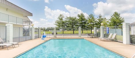 Una piscina al aire libre de temporada, sillones reclinables de piscina