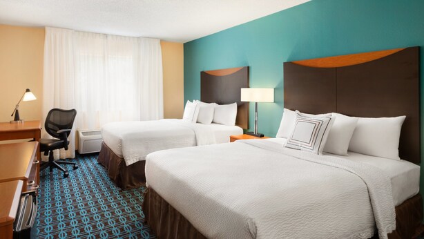 A hotel room with two beds, a desk, and a chair. - AmeriVu Inn and Suites Grand Forks (Grand Forks)