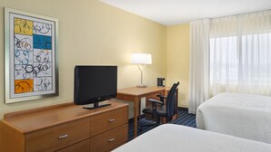 A hotel room with a bed, a desk with a computer, a TV, a lamp, and a framed artwork on the wall. - AmeriVu Inn and Suites Grand Forks (Grand Forks)