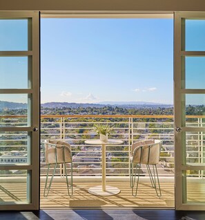 A balcony with a table and two chairs, offering a city view. - Cameo Beverly Hills, LXR Hotels & Resorts (Los Angeles)