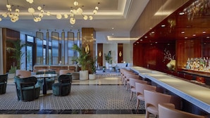 A modern lobby with a bar area, seating arrangements, and large windows. - Cameo Beverly Hills, LXR Hotels & Resorts (Los Angeles)