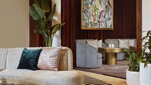 A modern living room with a sofa, armchairs, a coffee table, and a patterned rug. - Cameo Beverly Hills, LXR Hotels & Resorts (Los Angeles)