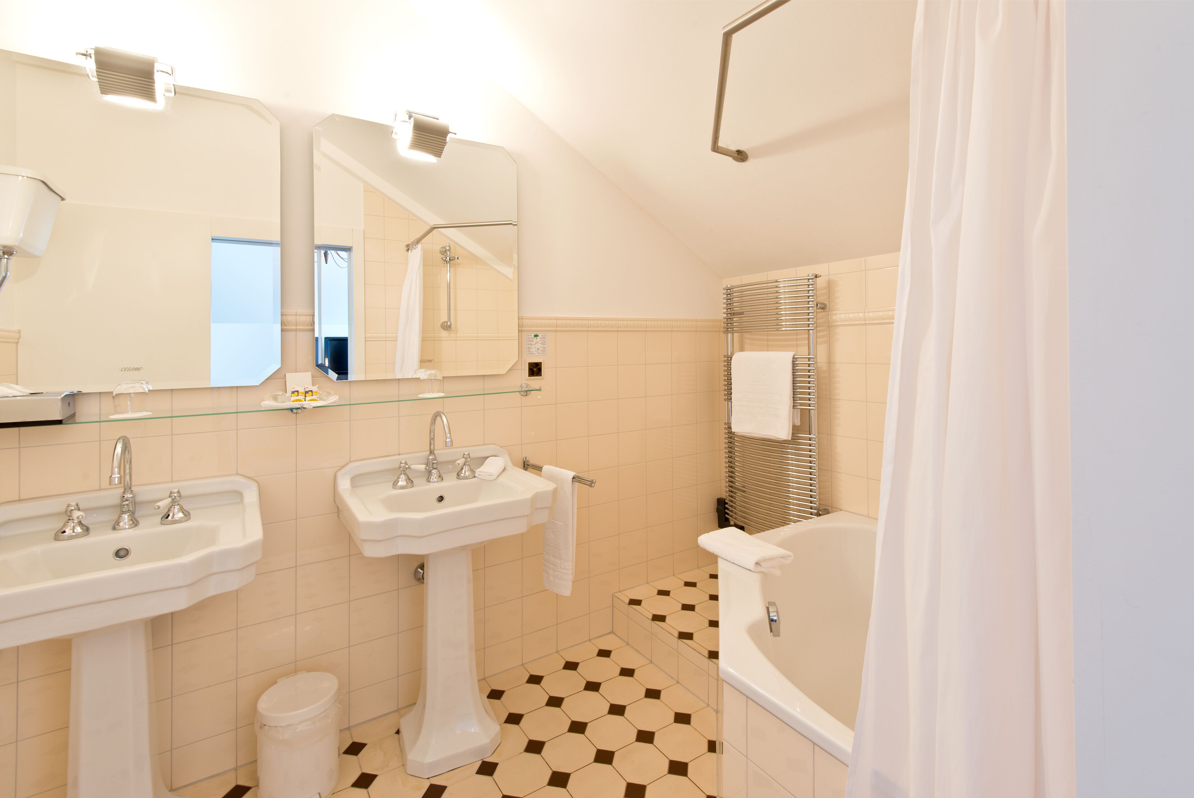 Une salle de bain moderne avec deux lavabos, une baignoire et une douche.