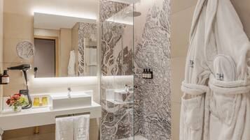 Un bagno moderno con doccia vetro, lavandino bianco e uno specchio grande.