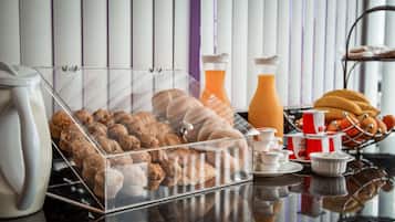 A breakfast display with pastries, a coffee machine, and condiments.
