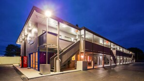 A modern building with a glass facade, a staircase, and a Coca-Cola vending machine. - SureStay Hotel by Best Western Findlay (Findlay)