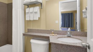 A bathroom with a sink, mirror, towel rack, and toilet.