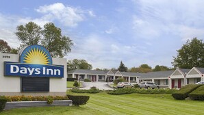 A Days Inn with a prominent sign, multiple motel units, and a well-maintained lawn.