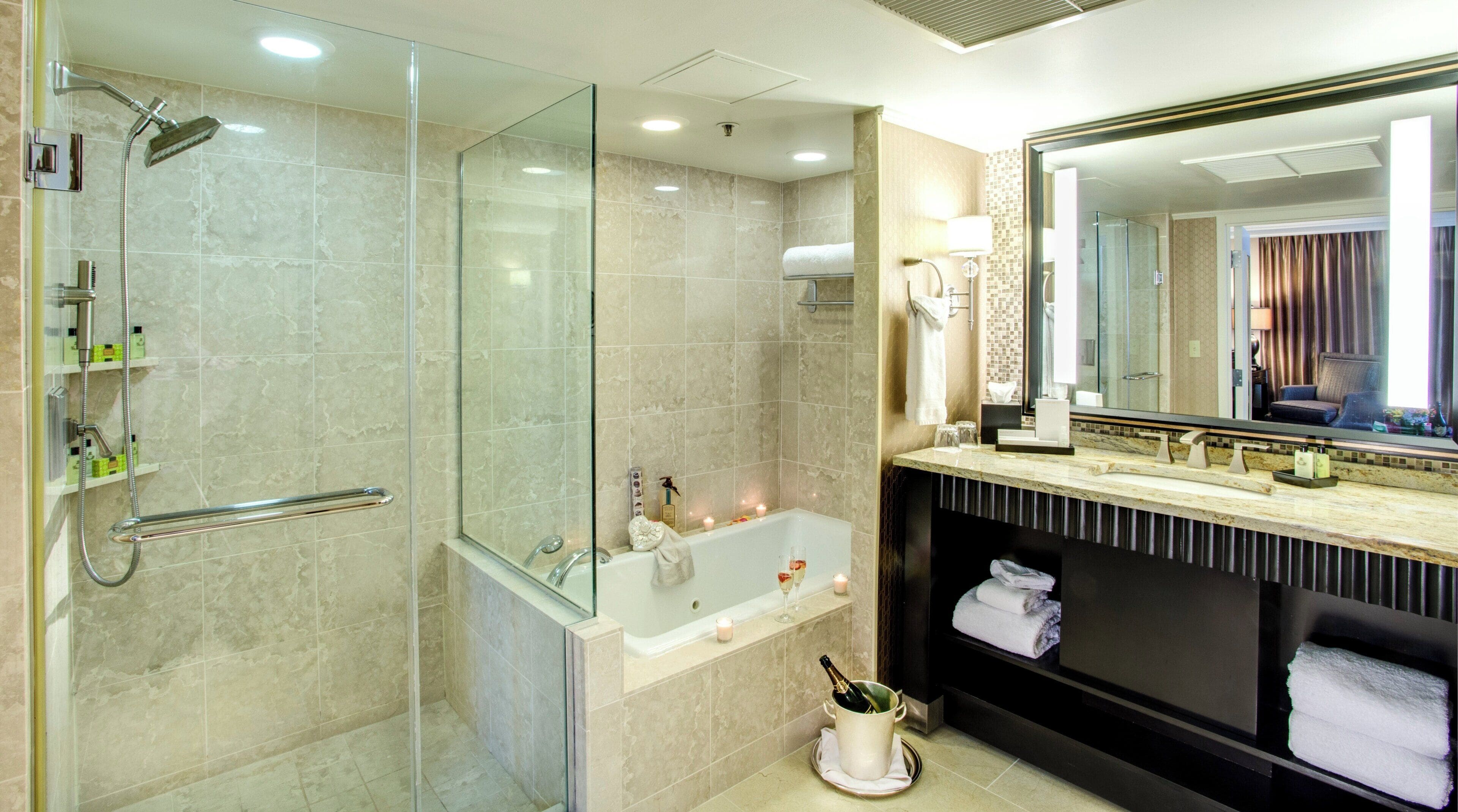 Une salle de bain moderne dotée d’une douche à parois de verre, d’une baignoire sur pieds et d’un meuble-lavabo avec un grand miroir.