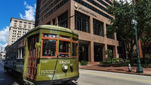 A green trolley with the number 932 on a street, passing by a building with the sign "InterContinental New Orleans". - InterContinental New Orleans by IHG (New Orleans)