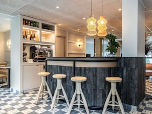 A modern bar area with a counter, stools, and a coffee machine. - Hotel Mercure Paris Boulogne Pont de Saint Cloud (Boulogne-Billancourt)