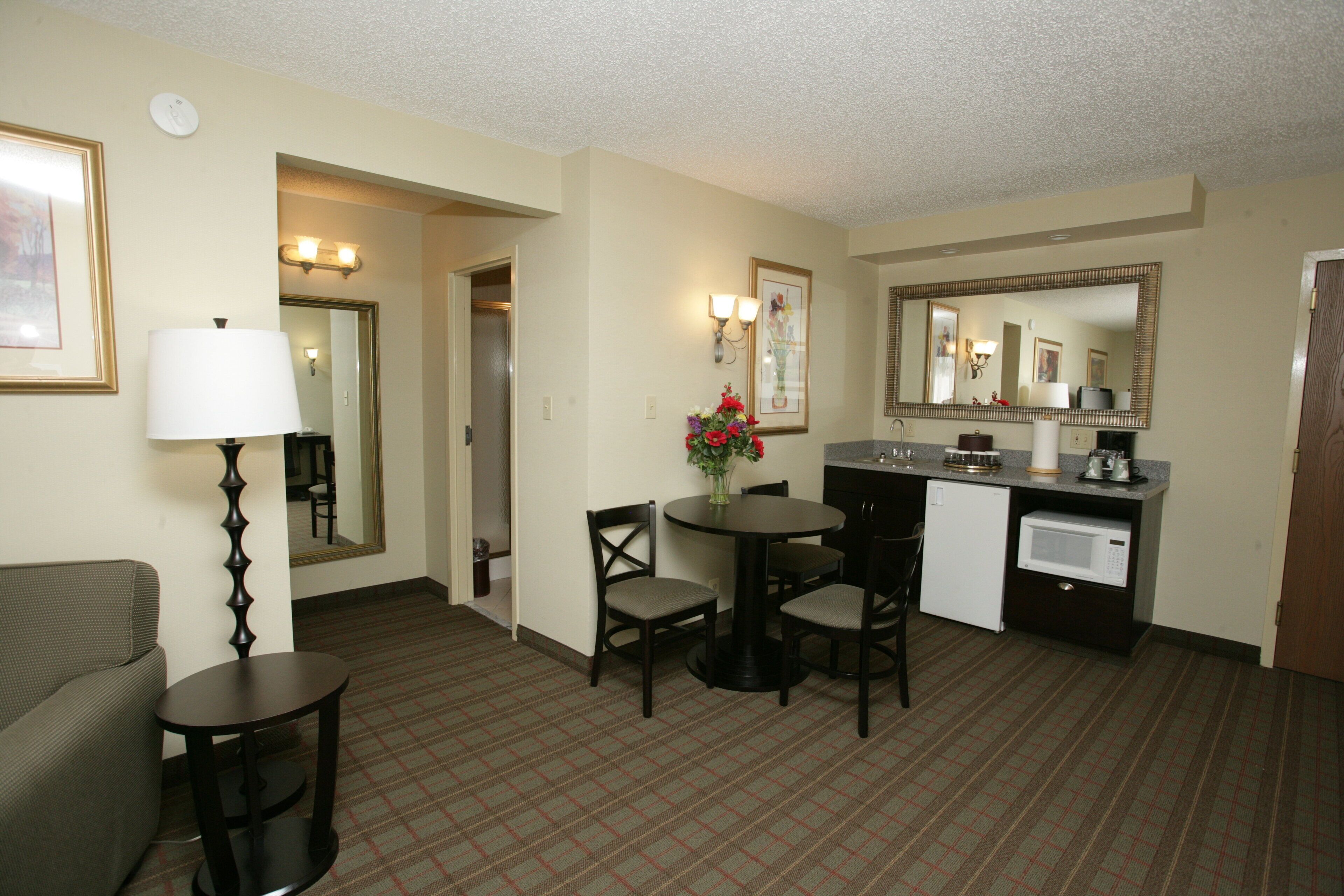 Une chambre d’hôtel comprenant un coin repas, une kitchenette, un lit et une salle de bain.