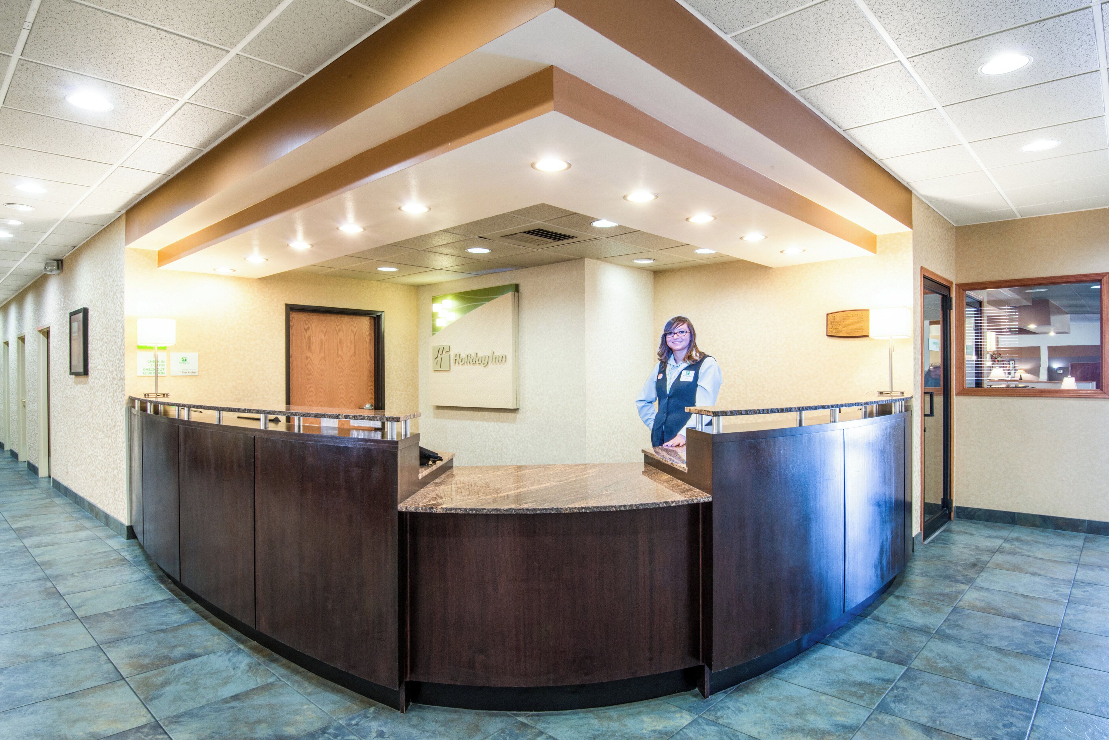 A reception desk with a wooden counter and a sign that reads 'Holiday Inn'.