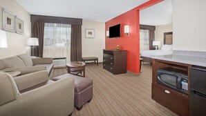 A hotel room with a living area, kitchenette, and a bed. - Holiday Inn Riverton by IHG (Riverton)