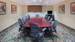 A conference room with a long table, chairs, a television, and framed artwork on the walls. - Holiday Inn Riverton by IHG (Riverton)