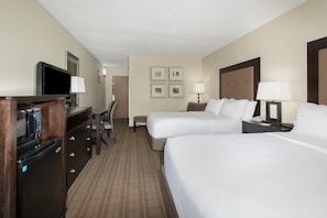 A hotel room with two beds, a desk with a computer, a television, and a refrigerator. - Holiday Inn Riverton by IHG (Riverton)
