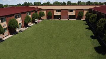 A building with a central courtyard, surrounded by brick buildings with red roofs.