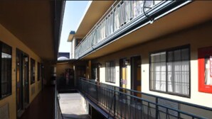 A corridor with a balcony, windows, and doors. - San Francisco Inn (San Francisco)