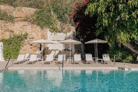 Una piscina techada, una piscina al aire libre de temporada, sombrillas