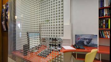 A modern office space with a desk, computer, and bookshelf.