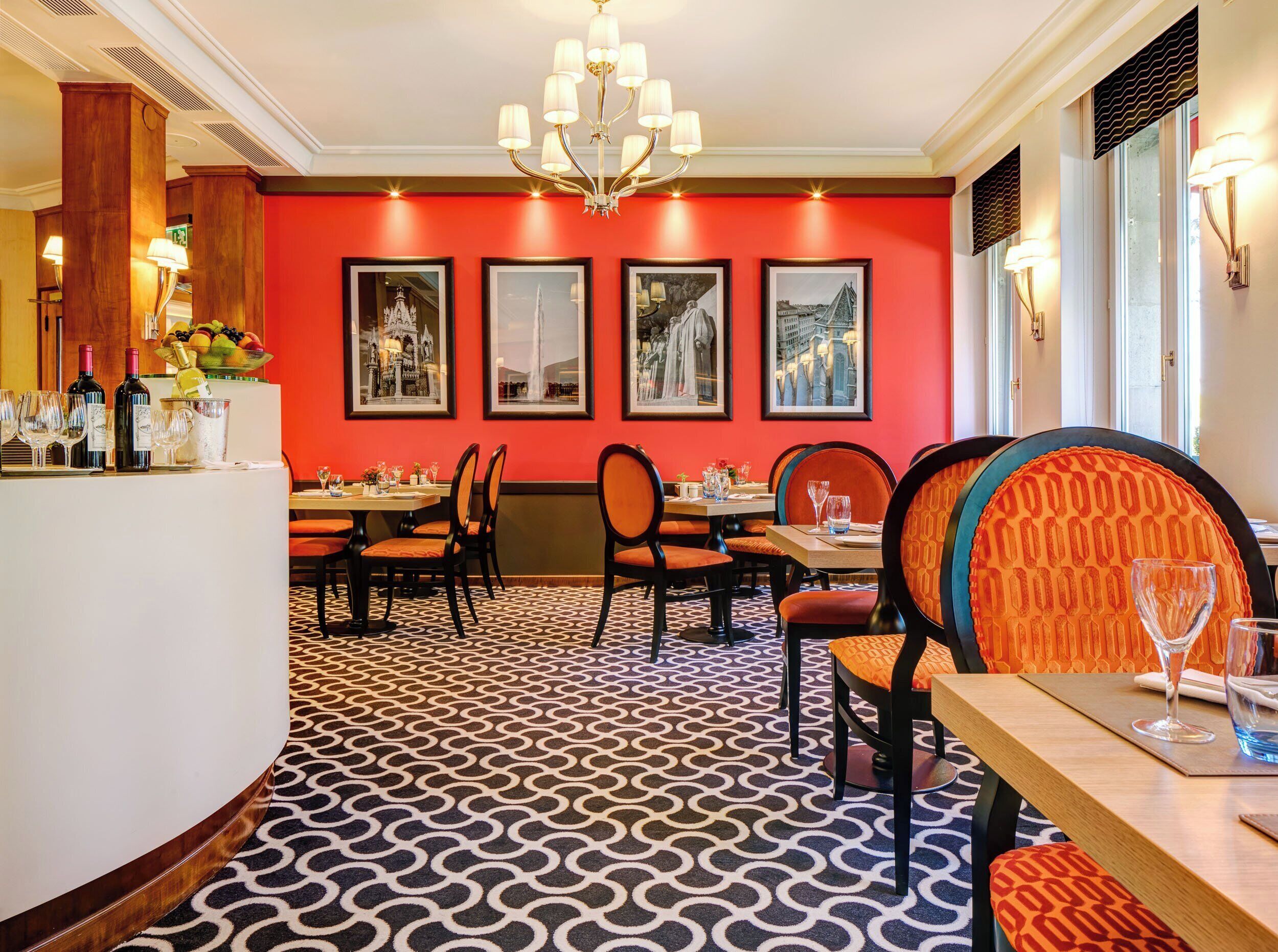Un ristorante con pareti rosse, opere d'arte incorniciate e un pavimento a motivi.