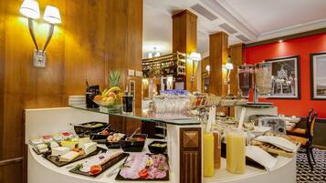 Ein Buffet mit verschiedenen Speisen, darunter Käse, Fleisch und Obst.