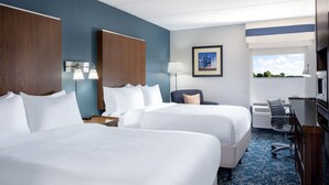 A hotel room with two beds, a desk, a chair, a lamp, and a picture on the wall. - Four Points by Sheraton Mall of America Minneapolis Airport (Richfield)