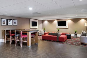 A hotel lobby with a bar area, seating, and artwork on the walls. - Four Points by Sheraton Mall of America Minneapolis Airport (Richfield)