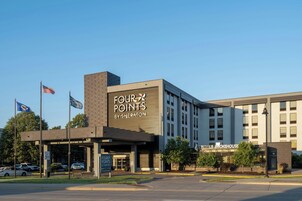 Um hotel com uma grande placa indicando 'FOUR POINTS BY SHERATON' e um 'LYNDAL SMOKEHOUSE' ao lado.