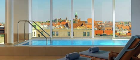 Zona de piscina con vistas a un paisaje urbano, incluyendo una destacada aguja verde.