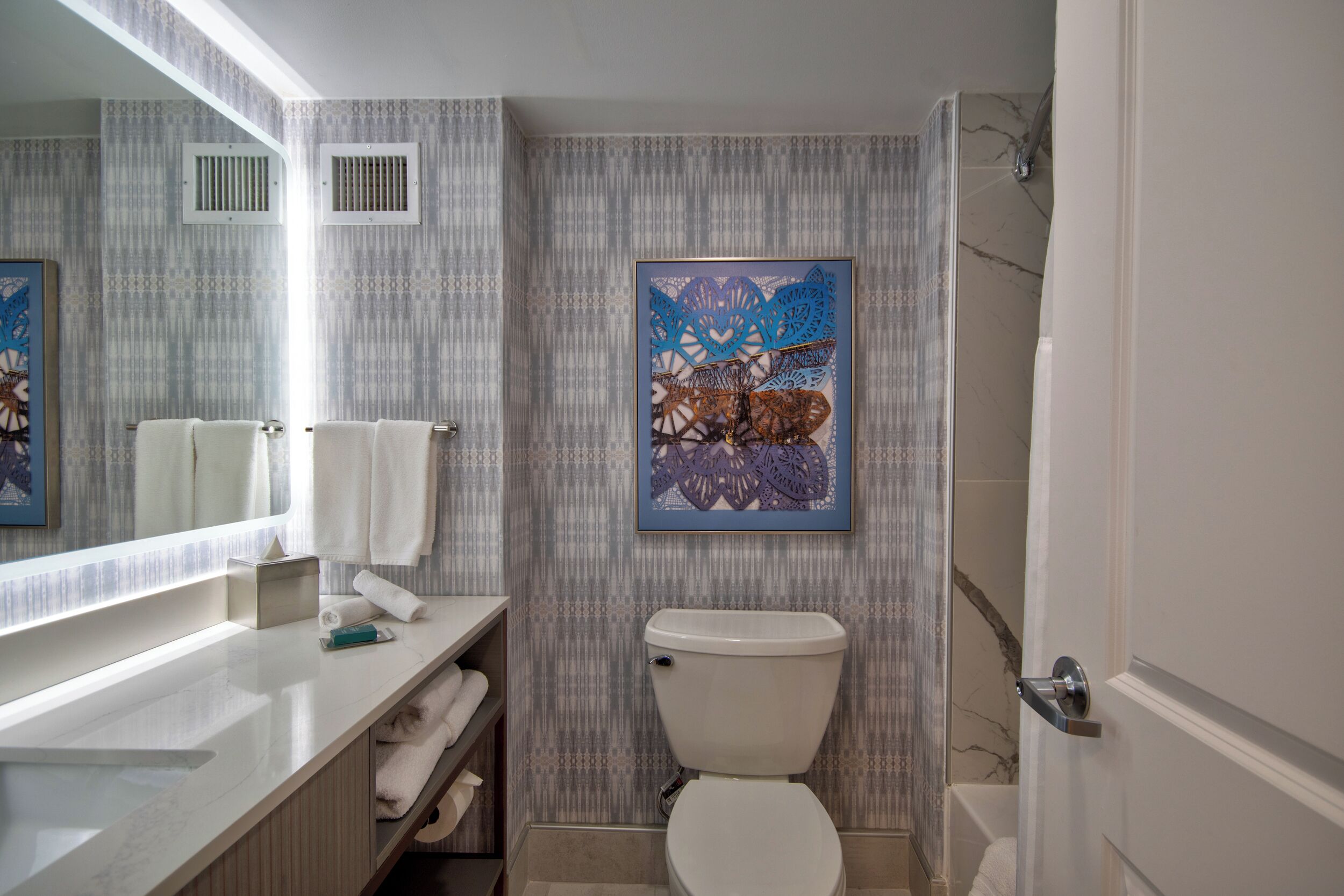 Une salle de bain comprenant des toilettes, un lavabo, un miroir et une douche.