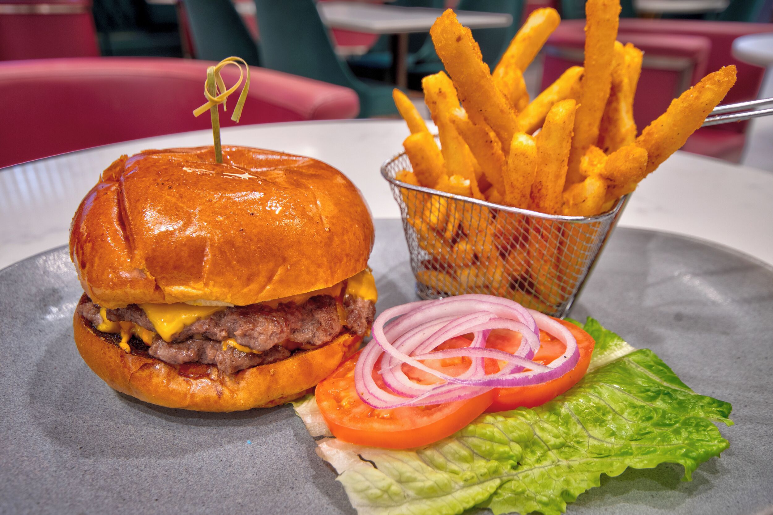 A burger with fries and a side salad on a plate.
