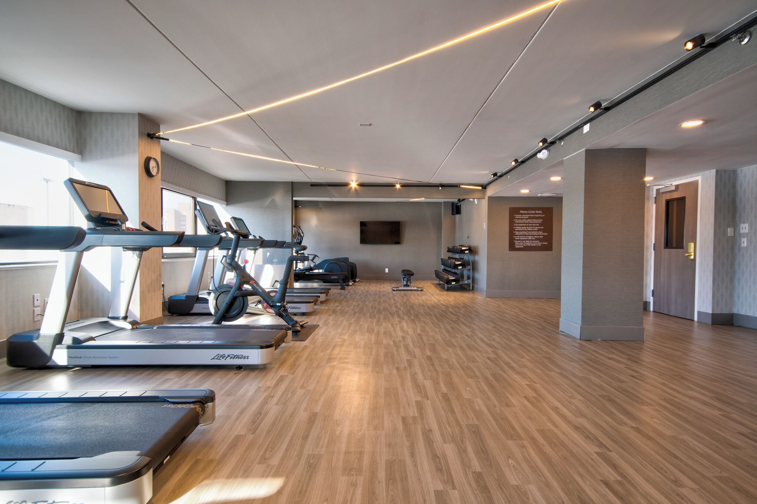 A gym with treadmills, stationary bikes, and a rowing machine.