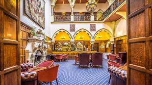 A grand lobby with a high ceiling, ornate wood paneling, and a central bar area. - Bestwood Lodge (Nottingham)