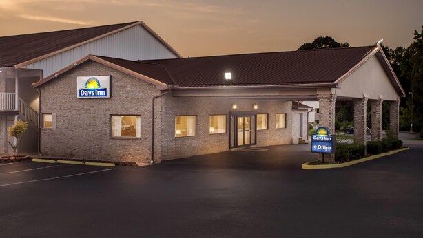 A Days Inn building with a brick facade, a flat roof, and a sign indicating the office location.
