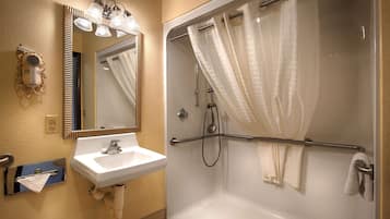 A bathroom with a white sink, mirror, and shower.