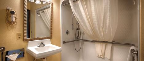 Une salle de bain avec un lavabo blanc, un miroir et une douche.