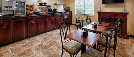 A restaurant with a coffee bar, seating area, and a fireplace.