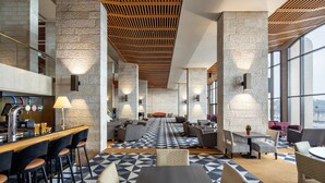 A modern hotel lobby with a bar area, seating arrangements, and large windows offering views. - Dan Jerusalem (Jerusalem)