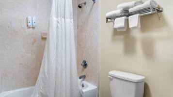 A bathroom with a shower, toilet, and towel rack.